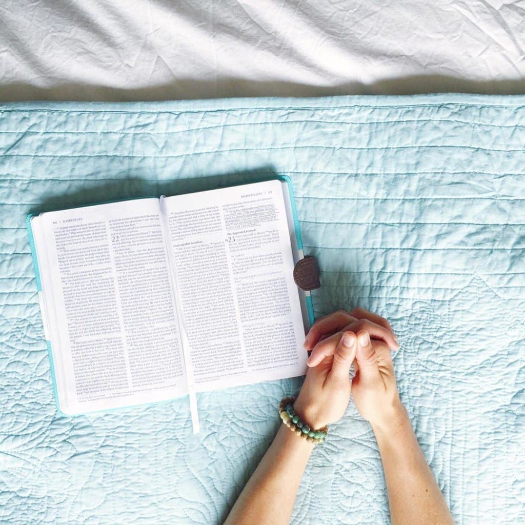 woman reading a bible and praying