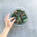 Mint Blueberry Kale Quinoa Salad with a women's hand picking up a blueberry.