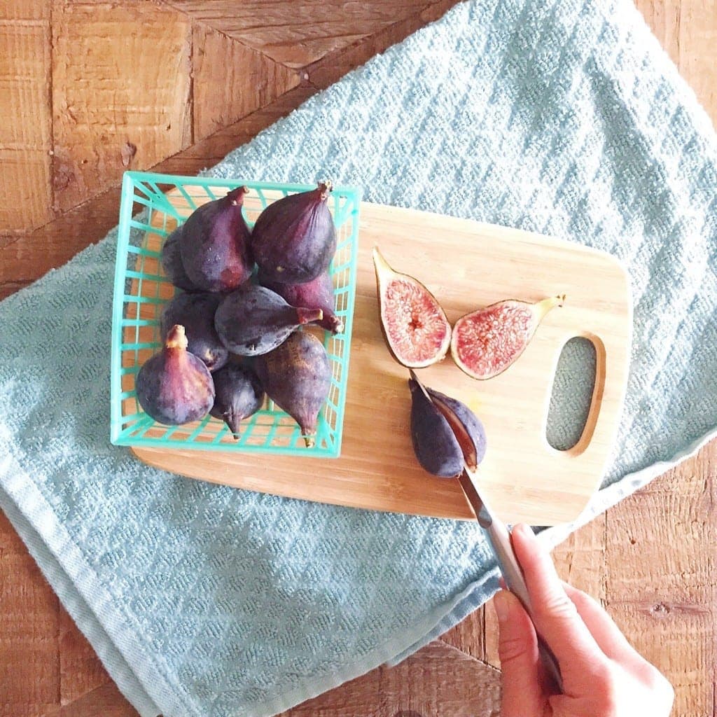 woman chopping figs on a cutting board