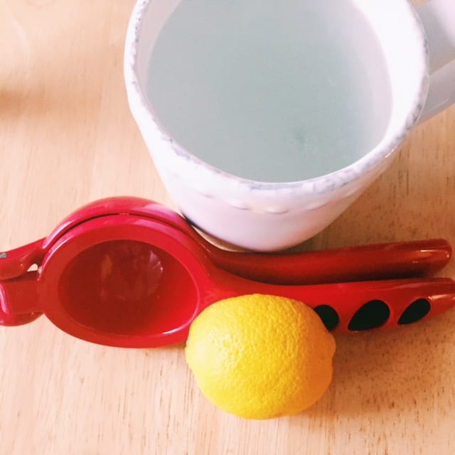 lemon squeezer next to a mug and lemon