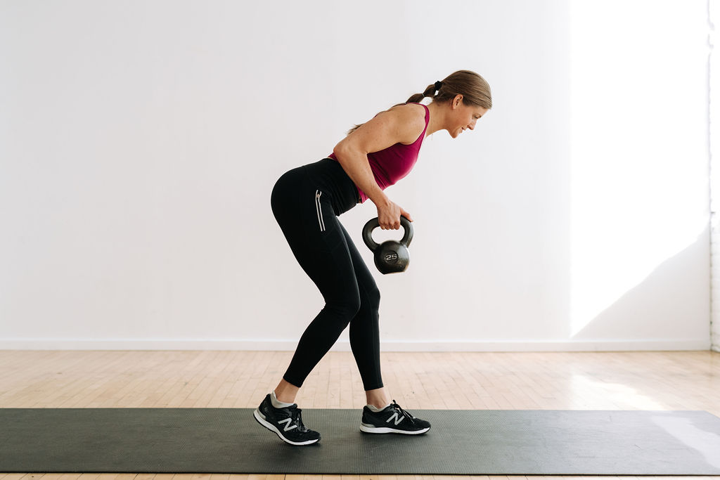 woman performing a single arm back row with a kettlebell as part of the best kettlebell exercises in a total body workout