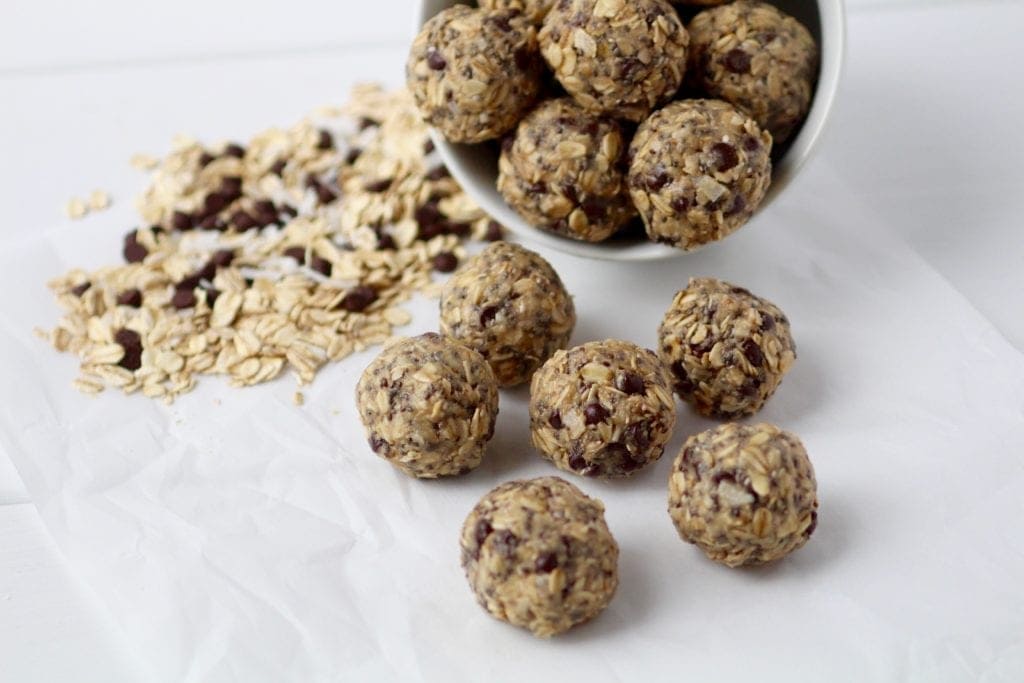 no-bake chocolate tahini energy bites in a bowl and on the counter