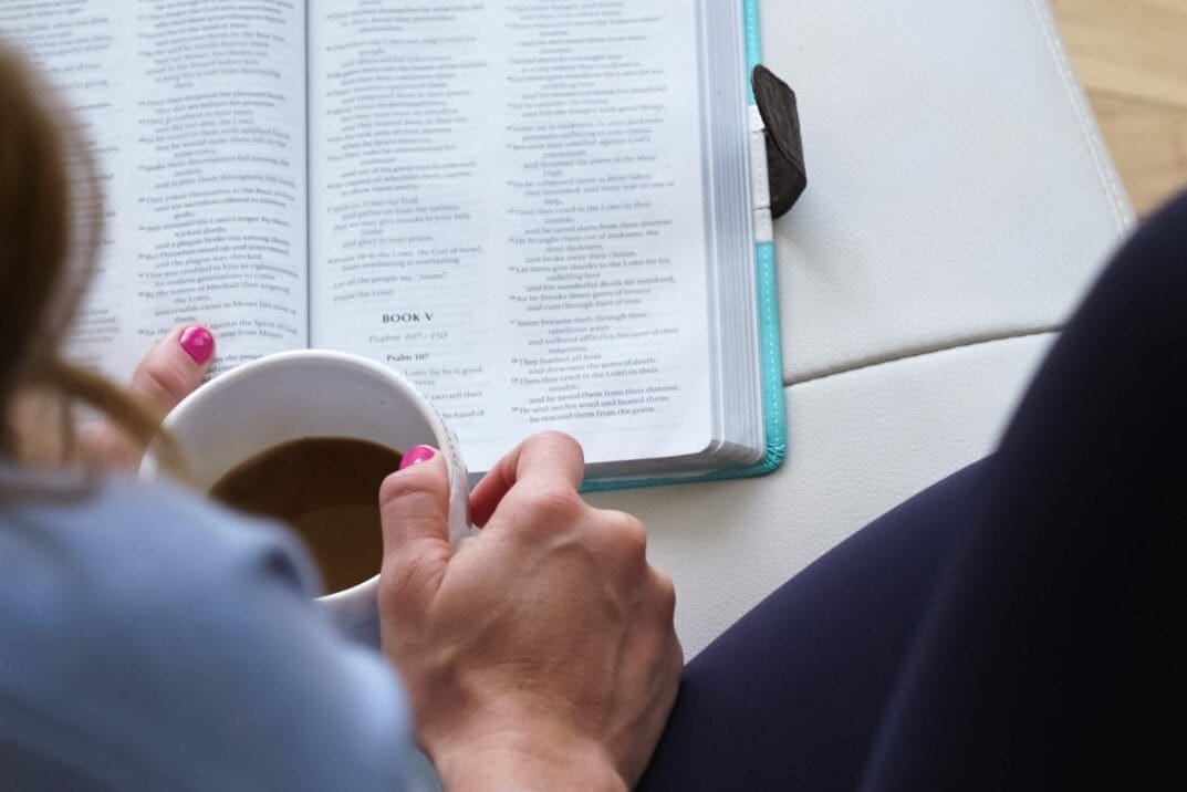 woman reading a bible with a cup of coffee