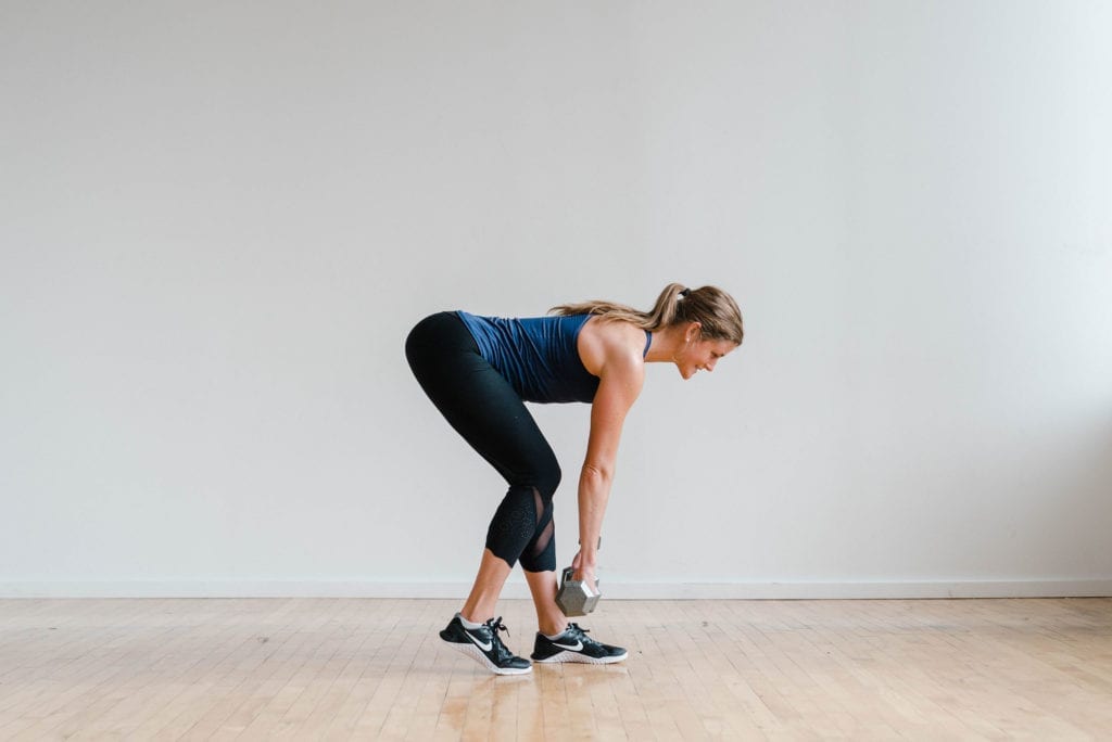 Woman performing a deadlift with dumbbells in a 30-Minute Leg Workout At-Home