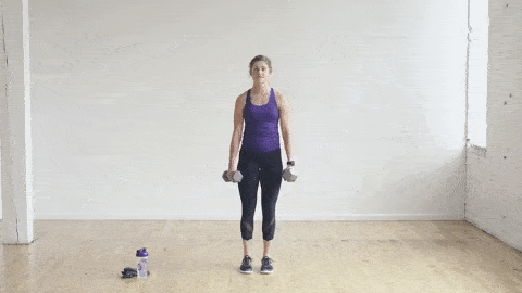 woman performing a reverse lunge with dumbbells in a leg workout at home