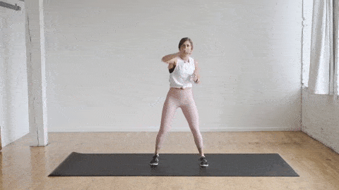woman performing alternating punches to warm up before a workout