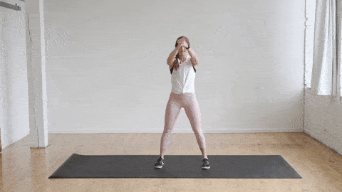 woman performing hip hinge swings or good mornings in a warm up routine