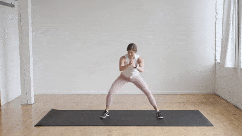 woman performing lateral lunges as part of a warm up