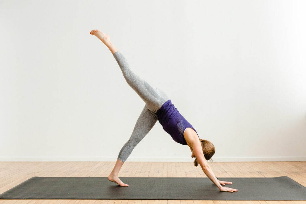 woman performing a three legged down dog pose in a power yoga flow