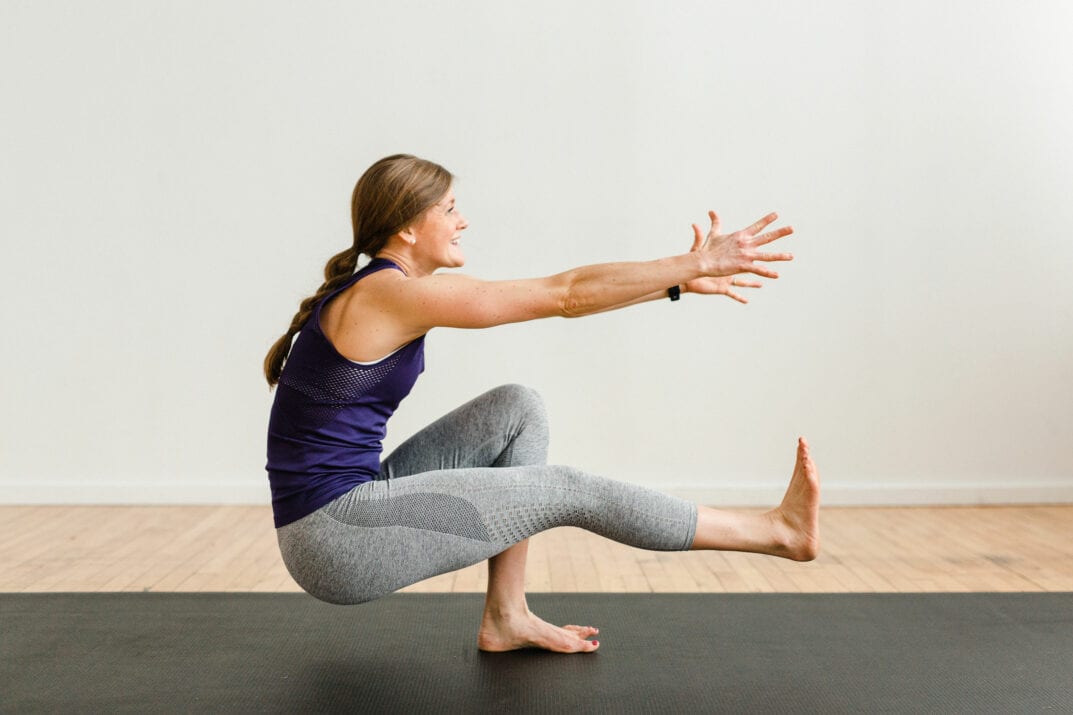 woman performing a pistol squat as part of a power yoga routine for strength and mobility