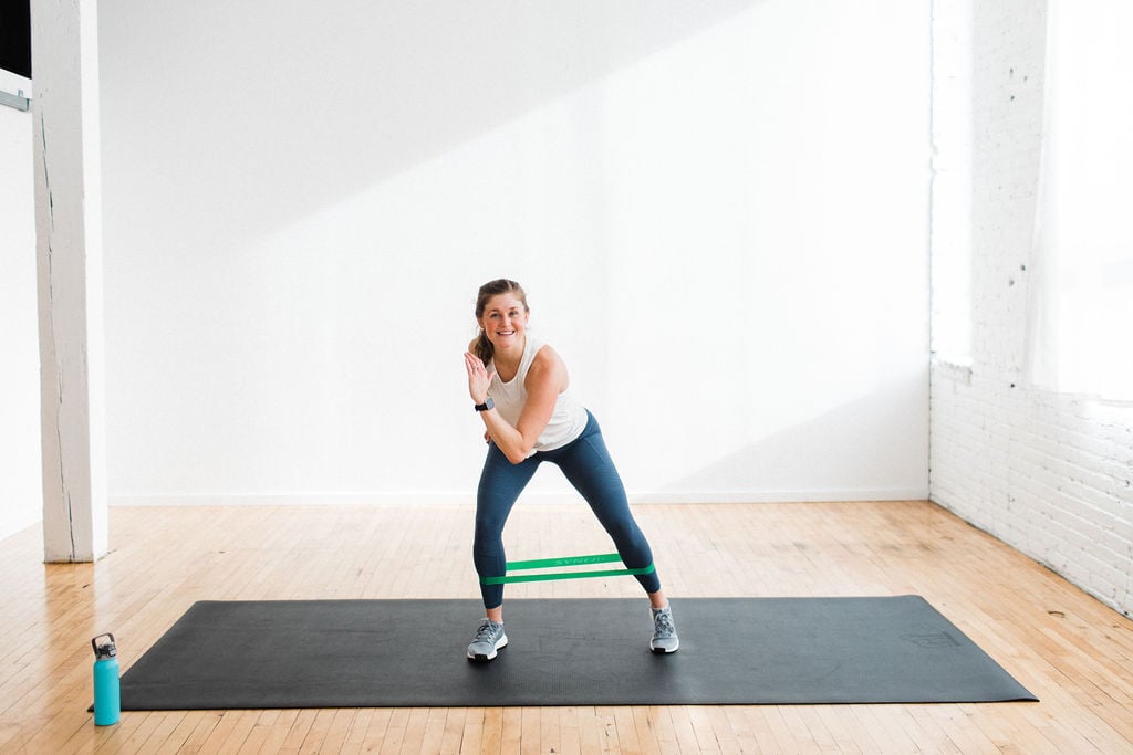 woman performing a lateral squat with a resistance band as part of the best booty band exercises 