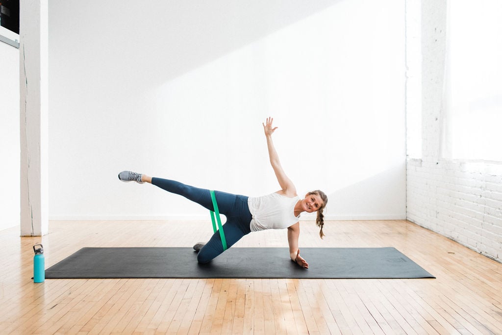 woman performing a side plank and crunch as part of the best booty band exercises