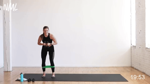 woman performing lateral walks with toe taps in a barre blend workout