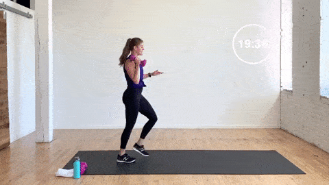 woman performing a 3 pulse lunge and dumbbell pass in a dumbbell lower body workout