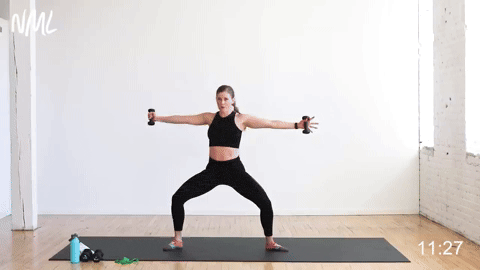 woman performing second position to lunge and press in a barre cardio workout