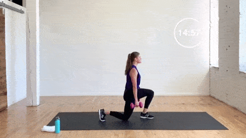 woman performing split lunges with dumbbells or split squats in a lower body workout with dumbbells
