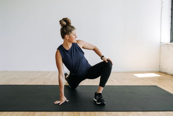 full body stretch routine. Women performing a runners lunge.