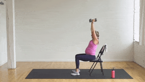 pregnant woman performing seated overhead tricep extensions and a chair squat in a prenatal strength workout