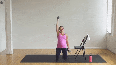 woman performing a kneeling single arm curl and press in a pregnancy workout