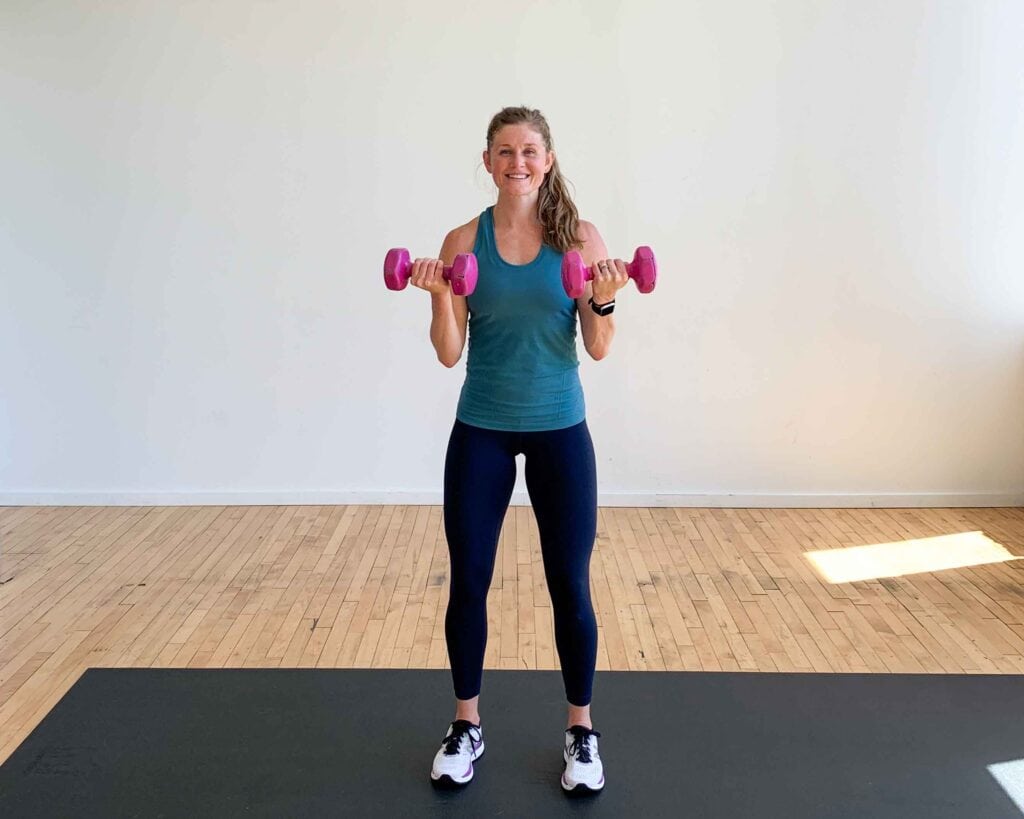 woman performing a bicep curl in a dumbbell hiit workout