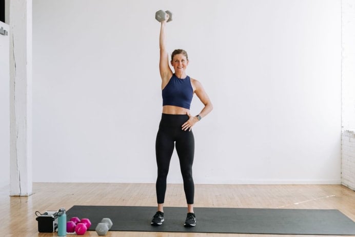 woman performing a single arm dumbbell overhead press