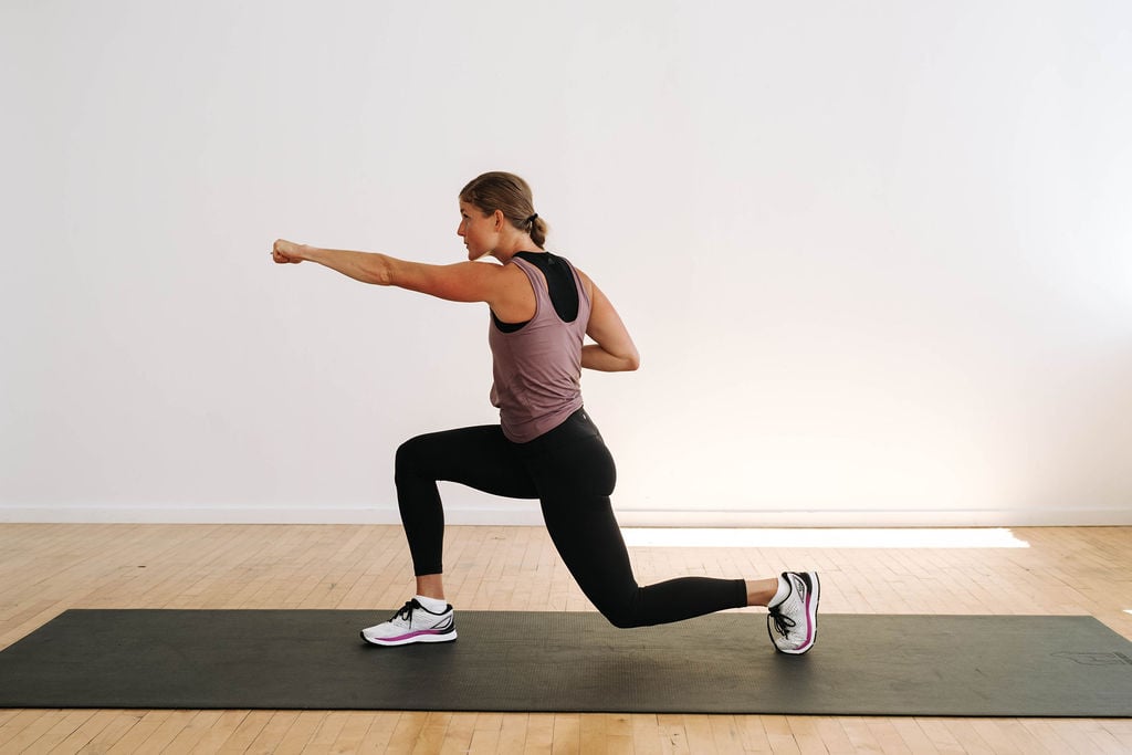 Woman performing a lunge hold and punch in a Cardio Kickboxing Workout At Home