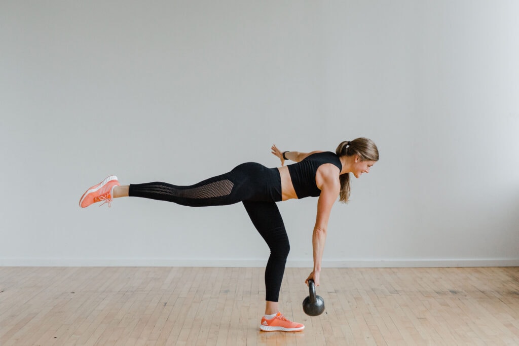 woman performing a single leg deadlift with a kettlebell in a leg workout