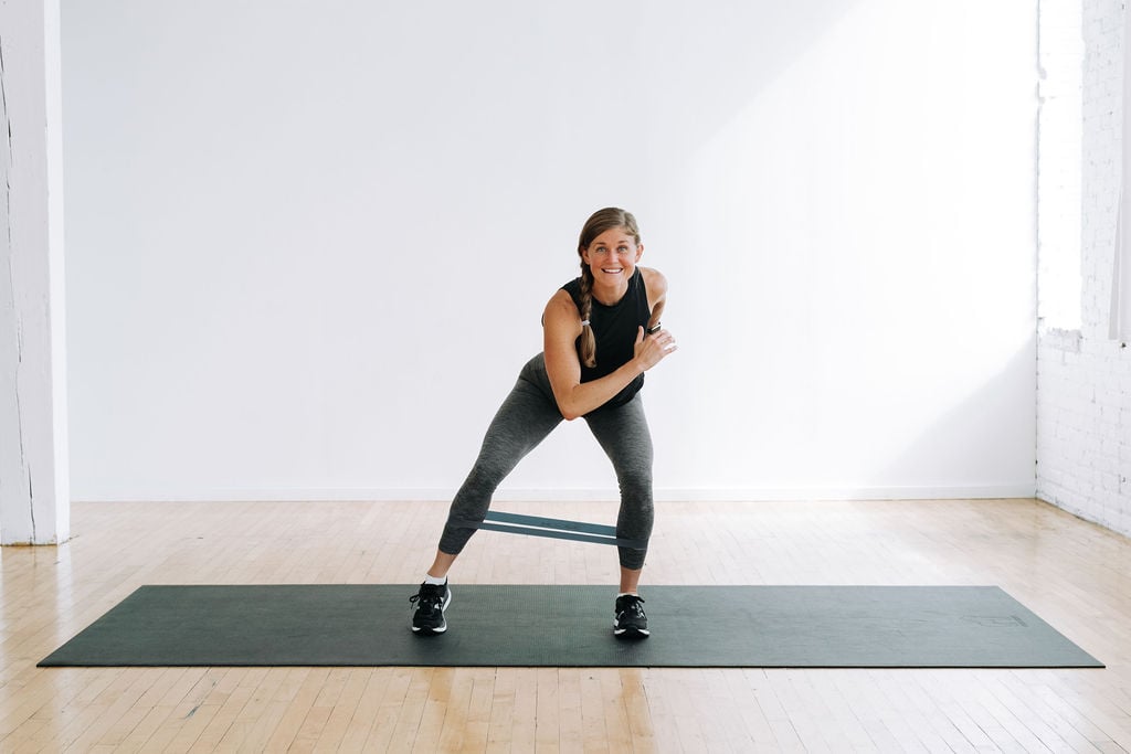 woman performing a single leg abduction as part of glute band exercises at home