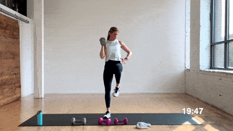 woman performing a lateral lunge balance press with free weights