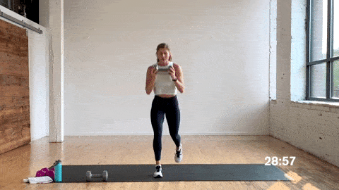 woman performing alternating lunge drops in a free weight workout