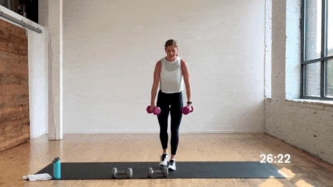 woman performing a reverse lunge, bicep curl, upright row with dumbbells in a free weight workout