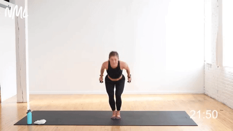 woman performing chair pose to an overhead press and knee drive in a cardio barre workout
