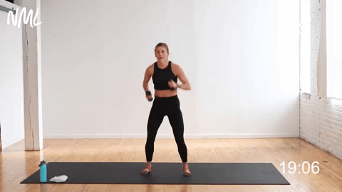 woman performing two jabs and two jacks with light hand weights in a cardio barre workout