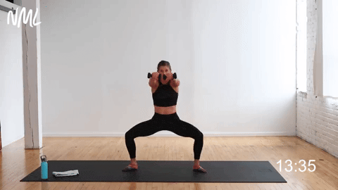 woman performing pulses in second position with a front punch in a cardio barre workout