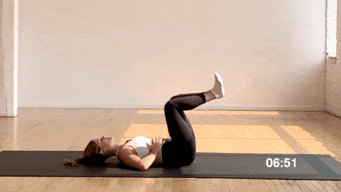postpartum woman performing elevated first position kick outs in a workout to heal diastasis recti