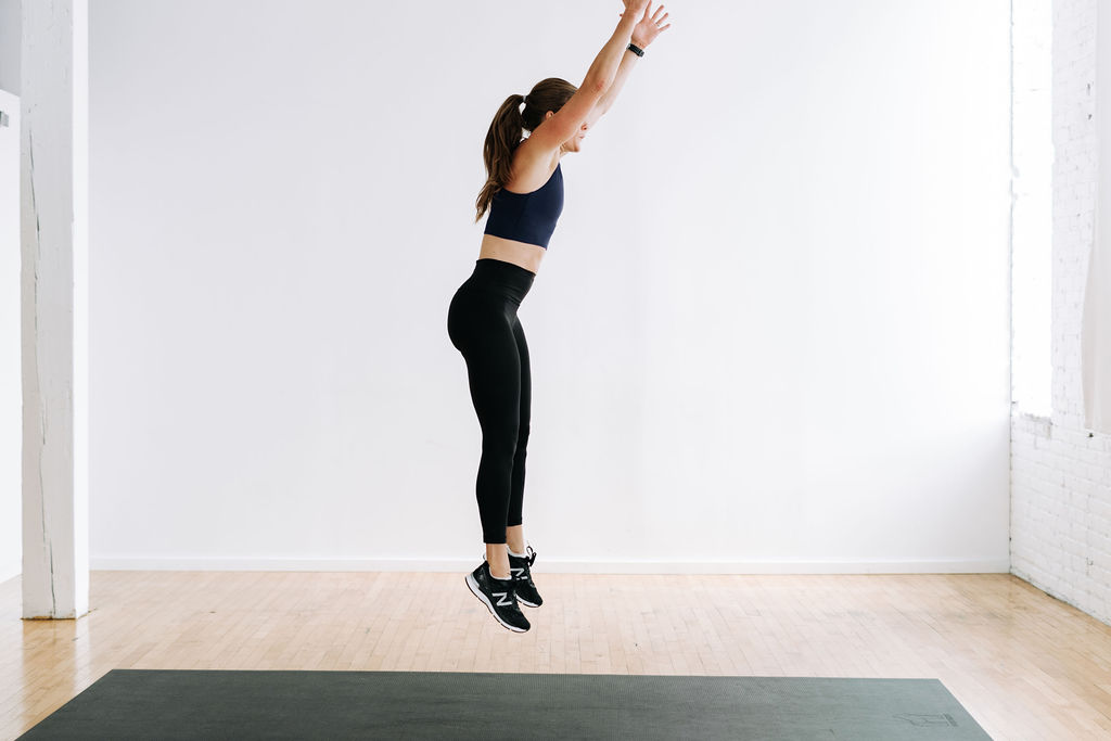 woman performing a burpee as part of a fat burning workout at home