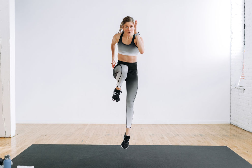 woman performing a high knee and jump in a legs and back workout