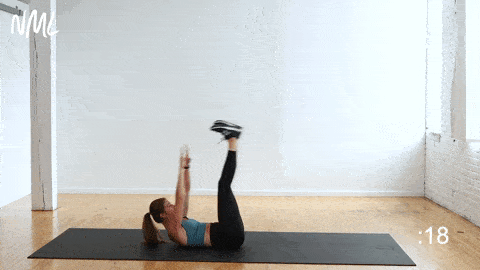 woman performing a v-up crunch in a 5-minute ab workout at home