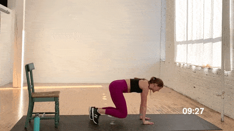 woman performing bear crawl kickbacks in an abs, butt and thigh workout