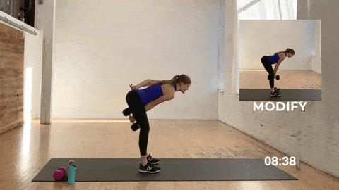 woman performing a dumbbell swing with a hand switch in a low impact beginner HIIT workout