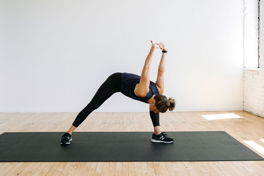 women performing a chest expansion forward fold during a stretching routine. 