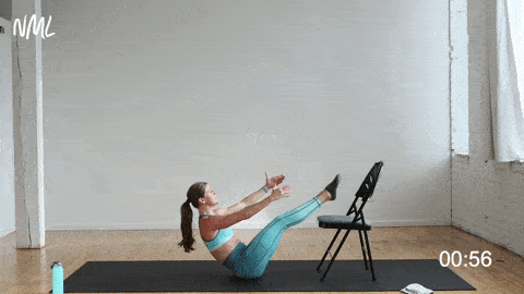woman performing boat pose as a core exercise in a barre workout