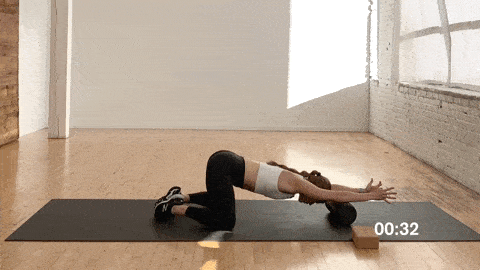 woman performing a child's pose stretch with arm extension or thoracic spine extension with foam roller