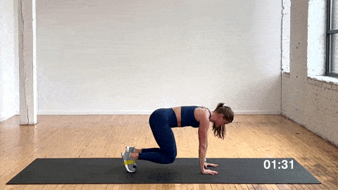 woman performing a bear crawl ab exercise with a resistance band