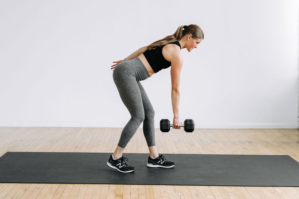 woman performing a single arm back row in a legs and back workout at home