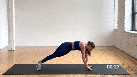 woman performing a rotating side plank with a resistance band in a resistance band ab workout