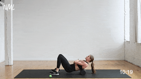 woman performing an upper back roll on a foam roller in a morning stretch routine