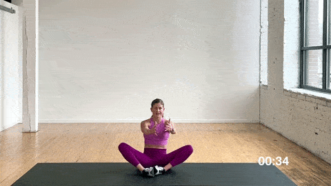 woman performing a 90/90 hip switch and kneel up in a dynamic warm up