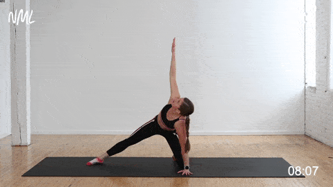 woman performing a half kneeling thoracic spine reach under (thread the needle) in an upper body stretch routine at home