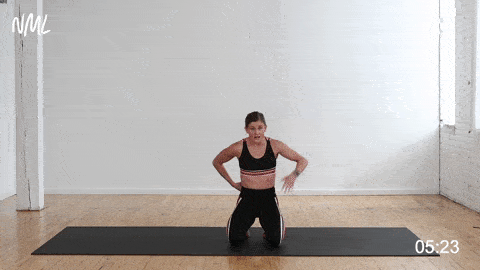 woman performing a kneeling reach across t-spine stretch in an upper body stretch routine